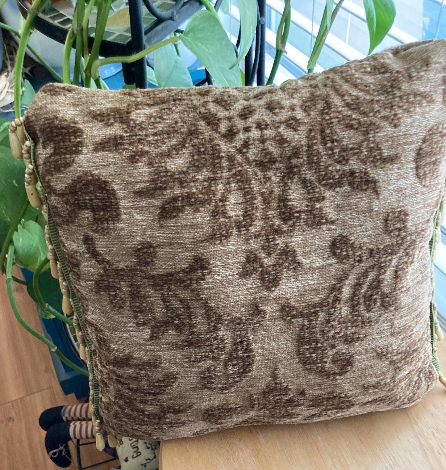 Tapestry accent pillow with beaded edges.