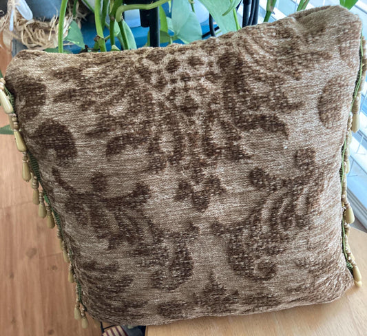 Tapestry accent pillow with beaded edges.