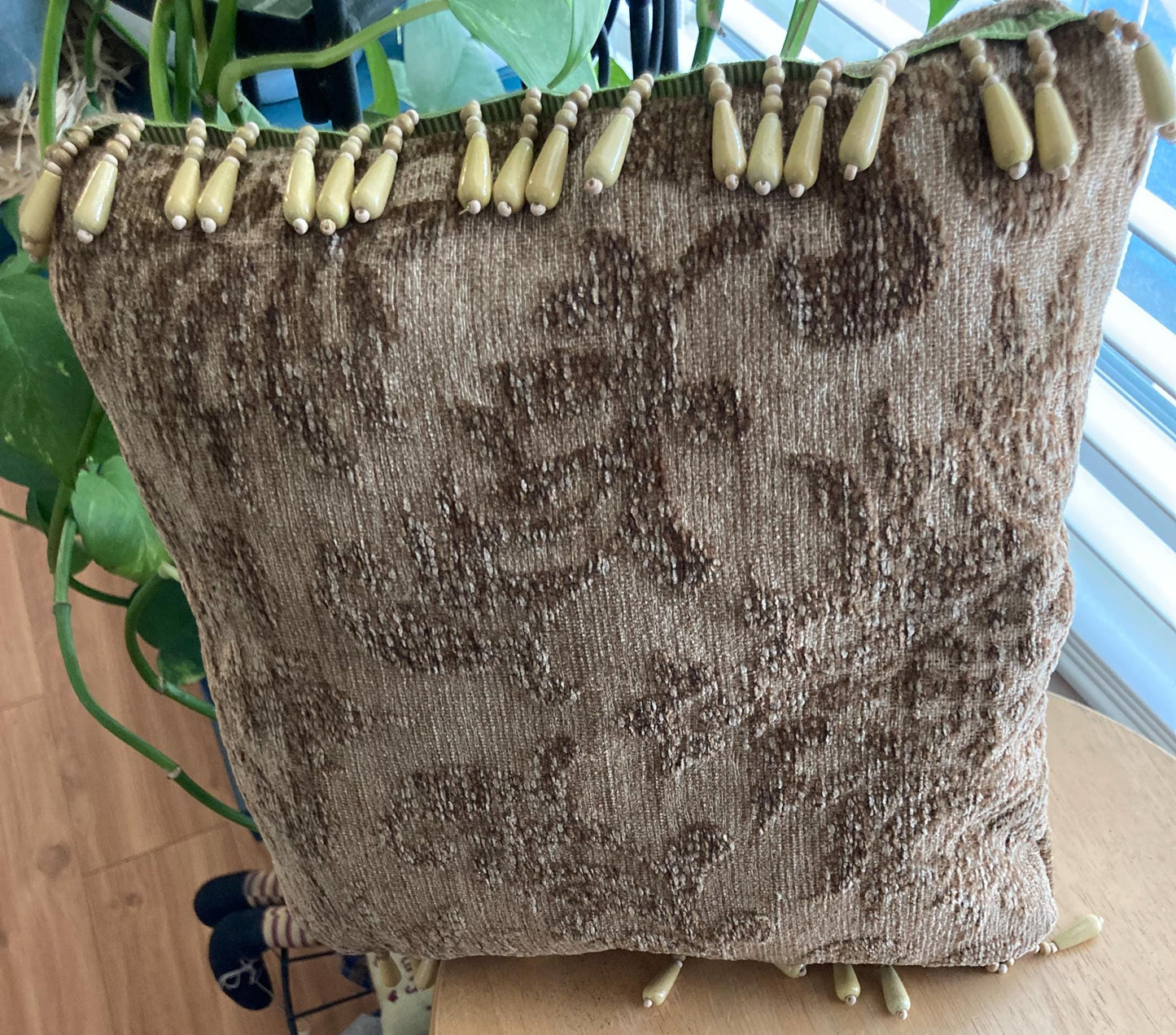 Tapestry accent pillow with beaded edges.